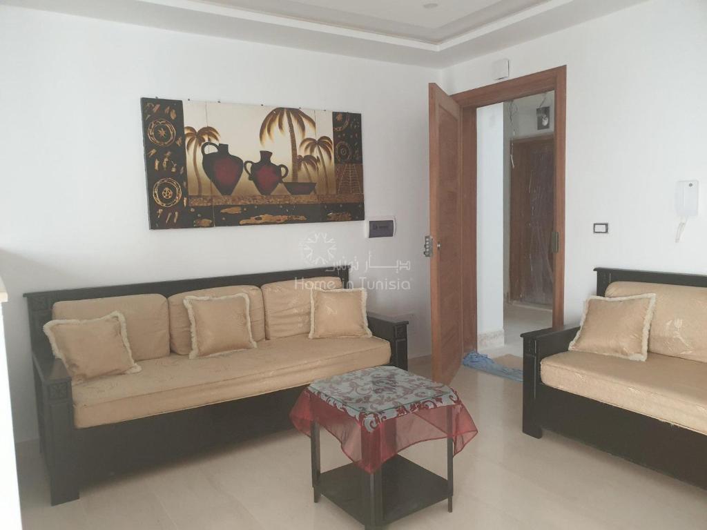 a living room with a couch and a table at appartement de vacance à corniche in Sousse