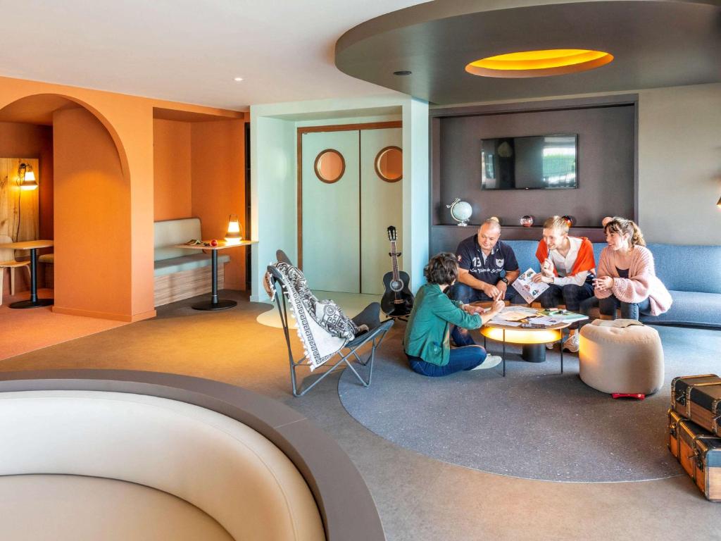 grupa ludzi siedzących w salonie w obiekcie IBIS STYLES Rouen Parc Expos Zenith w mieście Saint-Étienne-du-Rouvray