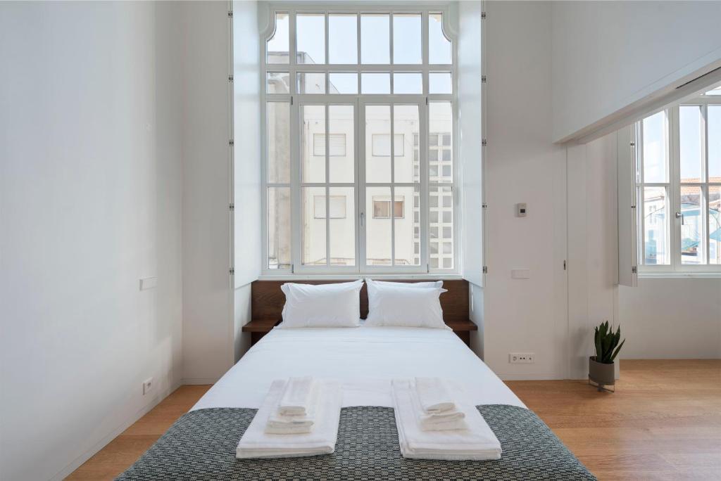 a bedroom with a large white bed with two pillows at Tripas-Coração, Santa Catarina in Porto