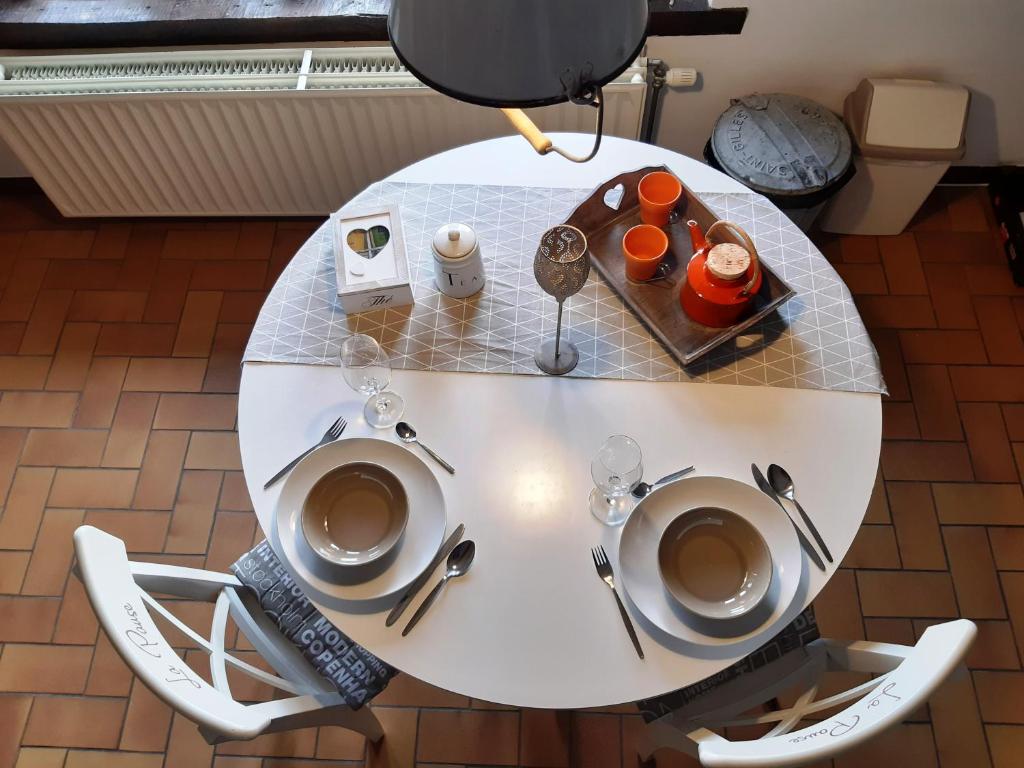 a white table with two cups of coffee on it at La Pause in Plombières