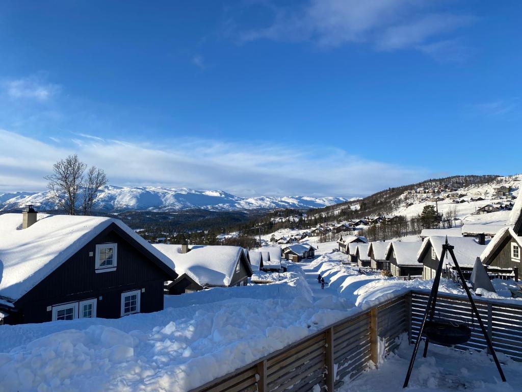 ein schneebedecktes Dorf mit Bergen im Hintergrund in der Unterkunft Endely - ski inn / ut in Rauland