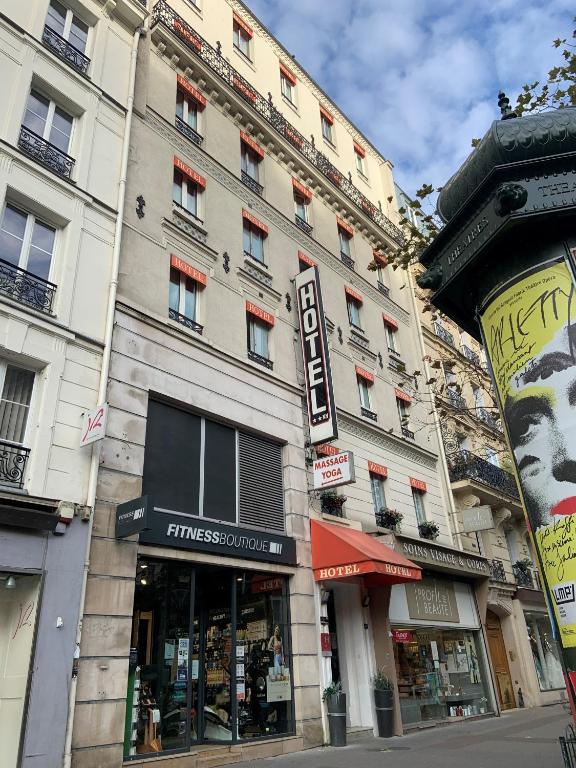 un bâtiment dans une rue de la ville avec un magasin dans l'établissement Hôtel Résidence Châtillon, à Paris