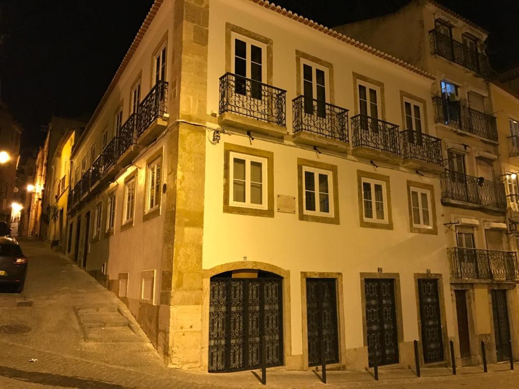 um grande edifício branco numa rua à noite em Palacette da Mouraria em Lisboa