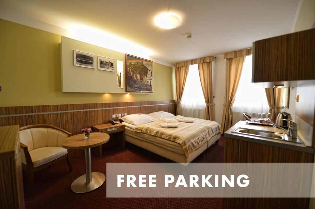 ein Hotelzimmer mit einem Bett und einem Waschbecken in der Unterkunft Hotel Vaka in Brünn