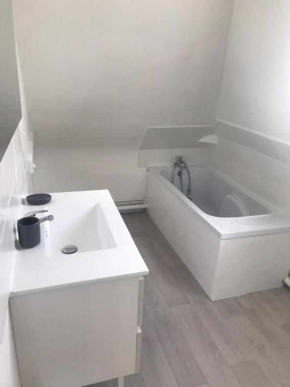 a white bathroom with a tub and a sink at Studio Lilouna avec parking privé in Le Tréport