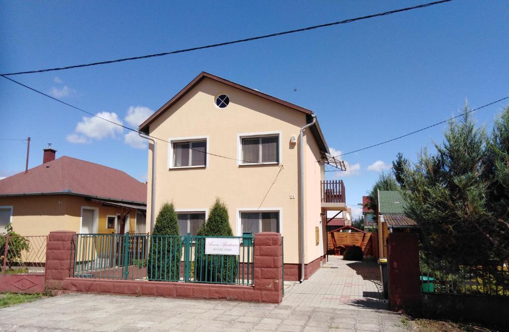 ein Haus mit einem Zaun davor in der Unterkunft Arinza Apartman Vendégház in Mezőkövesd