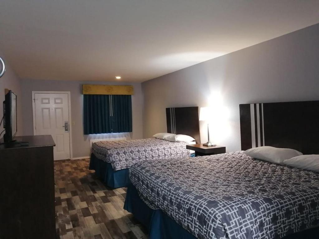 ein Hotelzimmer mit 2 Betten und einem TV in der Unterkunft Riata Inn - Crystal City in Crystal City