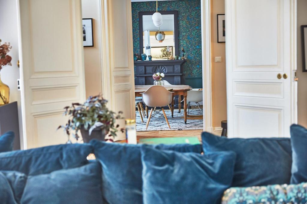 a living room with a blue couch and a table at Demeure de Manneville - SPA - 1Km des plages de Cabourg in Dives-sur-Mer
