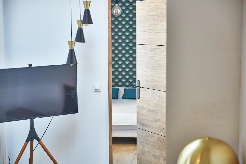 a mirror in a room with a television and a bed at Demeure de Manneville - SPA - 1Km des plages de Cabourg in Dives-sur-Mer