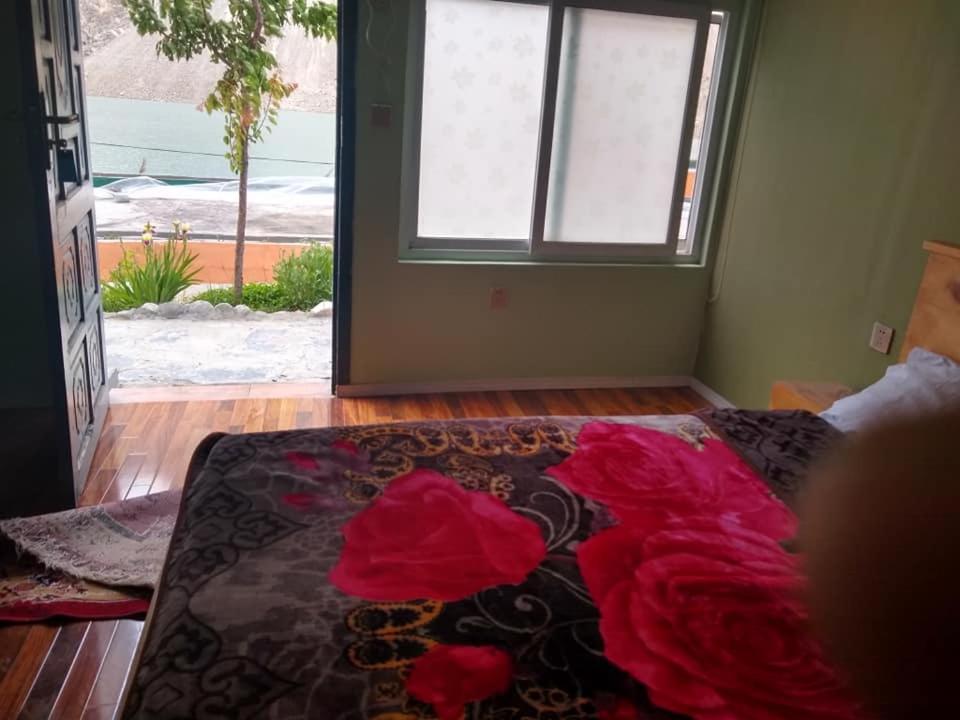 Un dormitorio con una cama con flores rojas. en Hidden valley Lake Resort, en Gircha