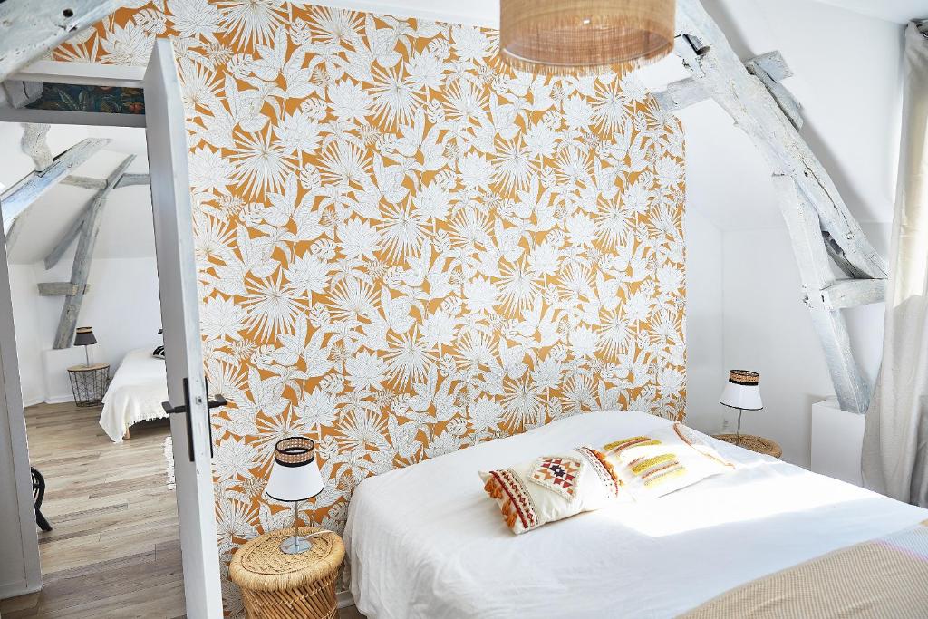 a bedroom with a white bed with a floral wallpaper at Demeure de Manneville - SPA - 1Km des plages de Cabourg in Dives-sur-Mer