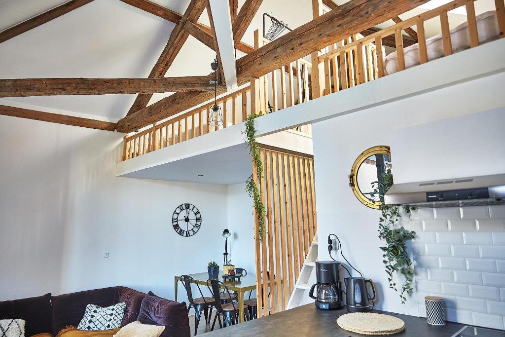 a kitchen and living room with a wooden ceiling at Demeure de Manneville - SPA - 1Km des plages de Cabourg in Dives-sur-Mer