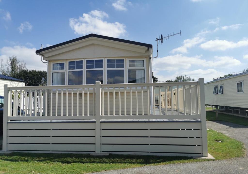 een klein huis met een wit hek bij Tranquil 6 Berth Luxury Holiday Home in Chichester