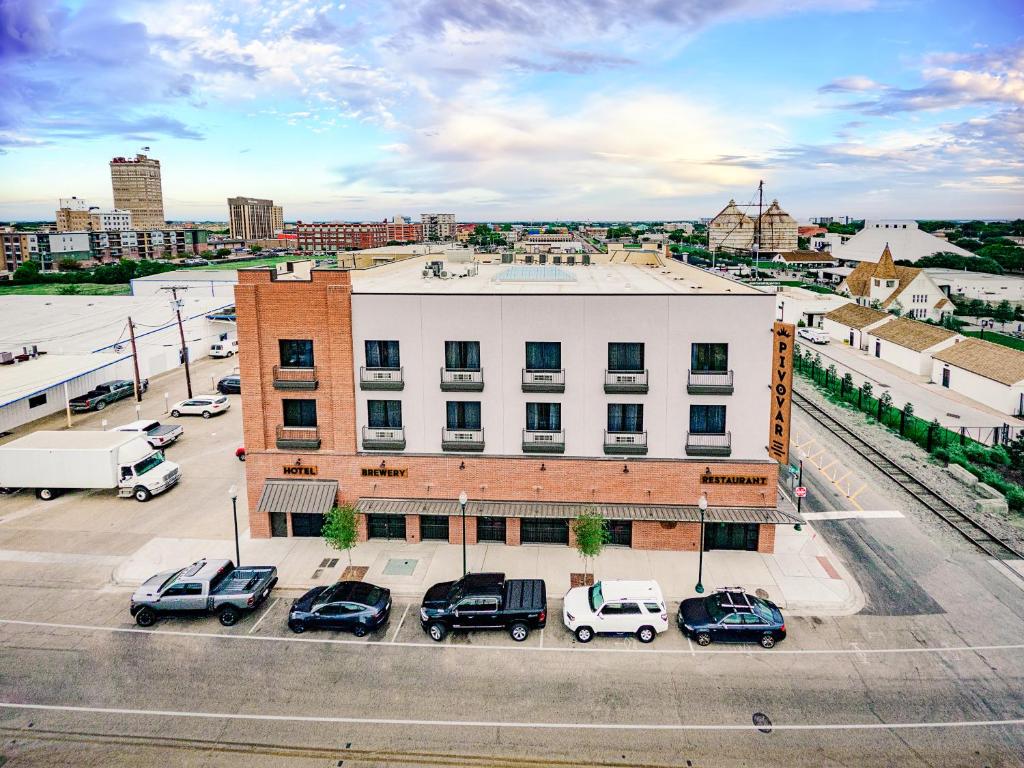 an aerial view of a building with cars parked in a parking lot at Pivovar Hotel in Waco