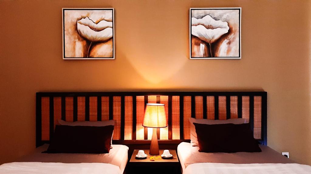 ein Schlafzimmer mit 2 Betten und einer Lampe auf einem Tisch in der Unterkunft Cuti de Gold Coast Morib in Banting