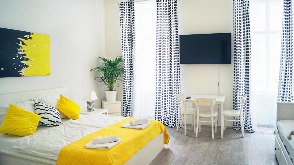 Cosy 1BR - Perfect for Long Stays في فيينا: غرفة نوم بسرير وبطانية صفراء