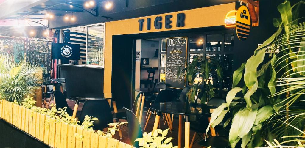 un restaurante con mesa, sillas y plantas en Tiger Hostel, en Medellín