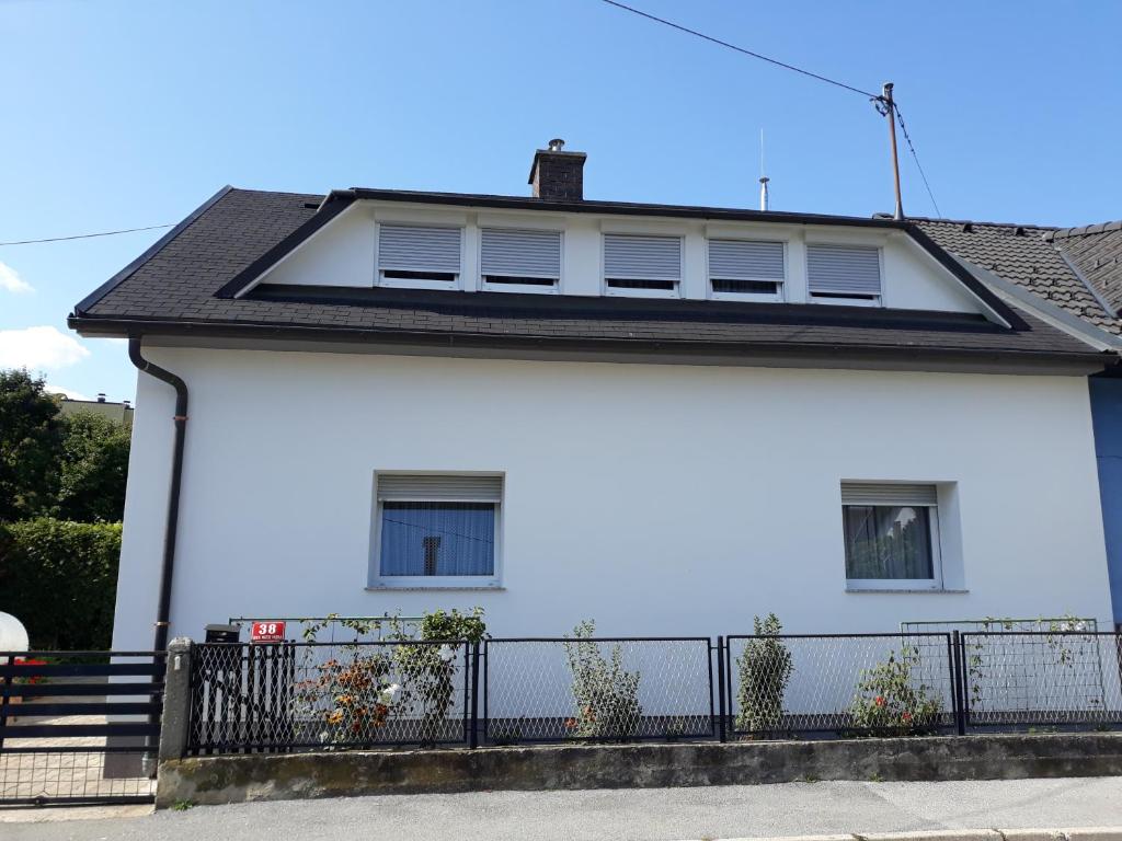 una casa blanca con una valla negra en Apartment Zorec en Maribor
