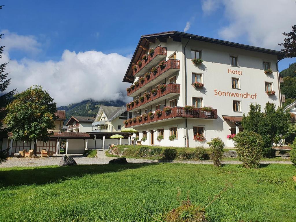 a large white building with a lawn in front of it at Hotel Sonnwendhof Engelberg in Engelberg