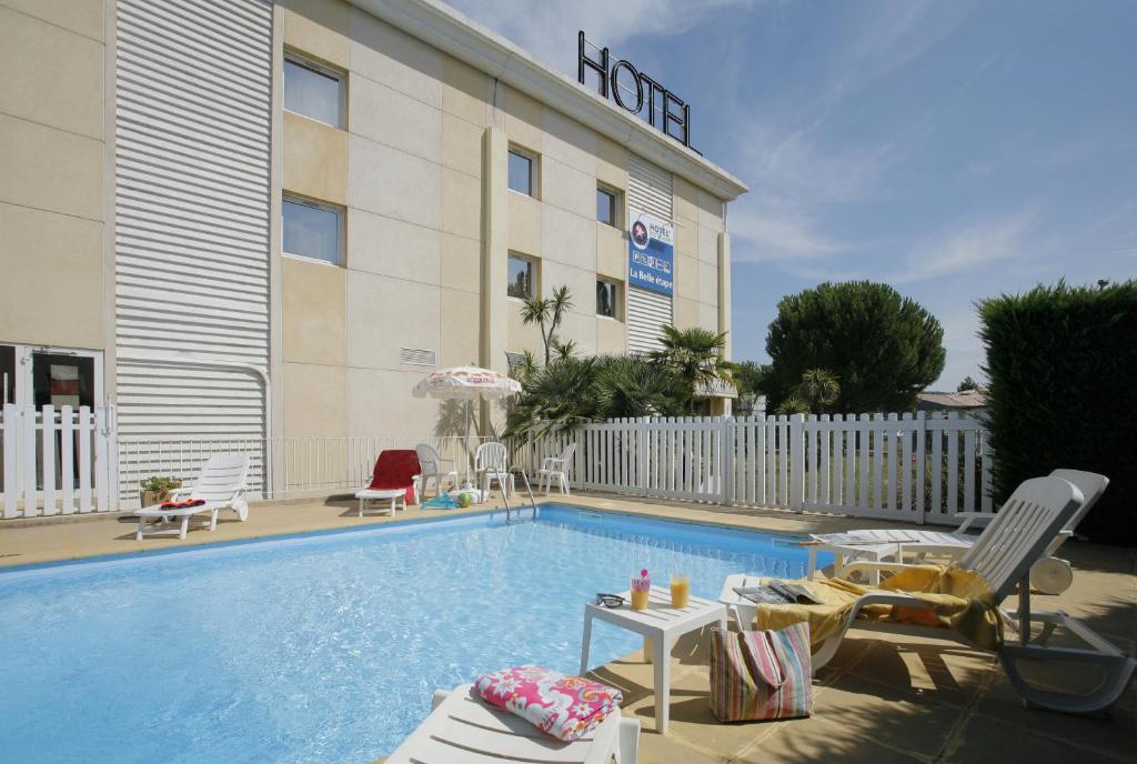 un hôtel avec une piscine et des chaises et un hôtel dans l'établissement The Originals City, Hôtel La Belle Étape, Brignoles (Inter-Hotel), à Brignoles