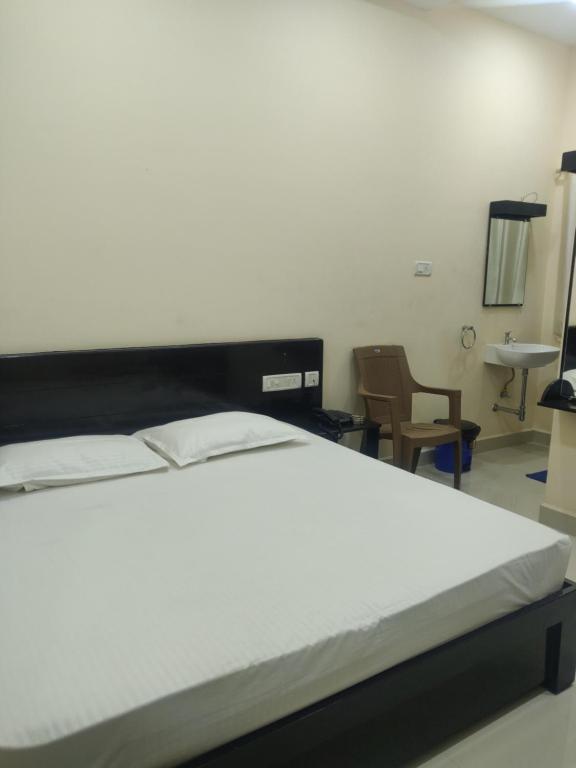 Postel nebo postele na pokoji v ubytování SRI VIGNESH RESIDENCY