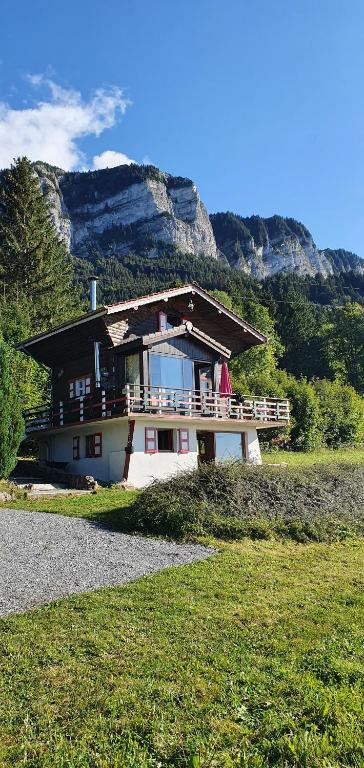 a house on a hill with mountains in the background at Chalet Nature in Thollon