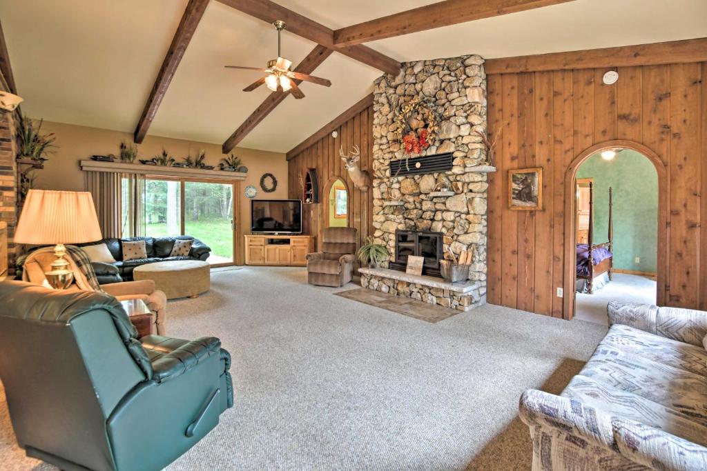 a living room with a stone fireplace in a house at Spacious Lakefront Home with Patio and Boat Dock! in Laporte