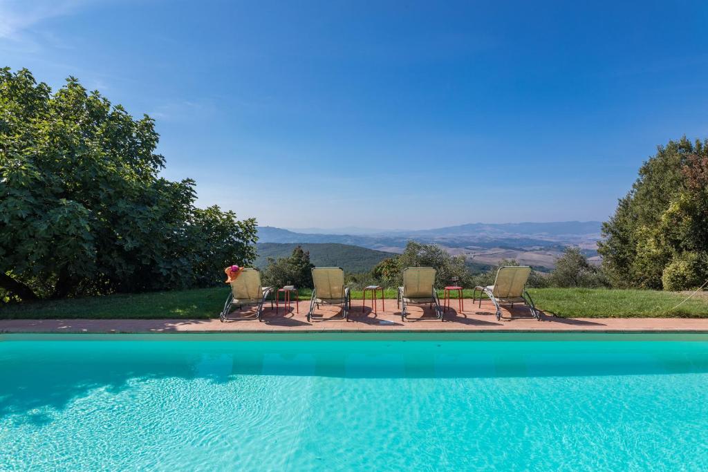 CastagnoにあるVilla Belvedereのプールの景色を望む客室で、椅子とテーブルが備わります。