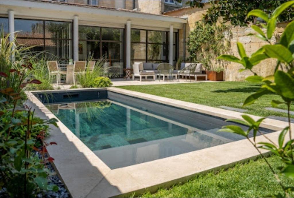 a swimming pool in the yard of a house at Le Clou de Louis in Bordeaux