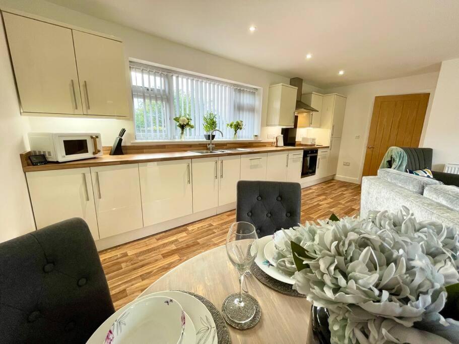 a kitchen and living room with a table and chairs at Stylish Boutique Bungalow in Felixstowe