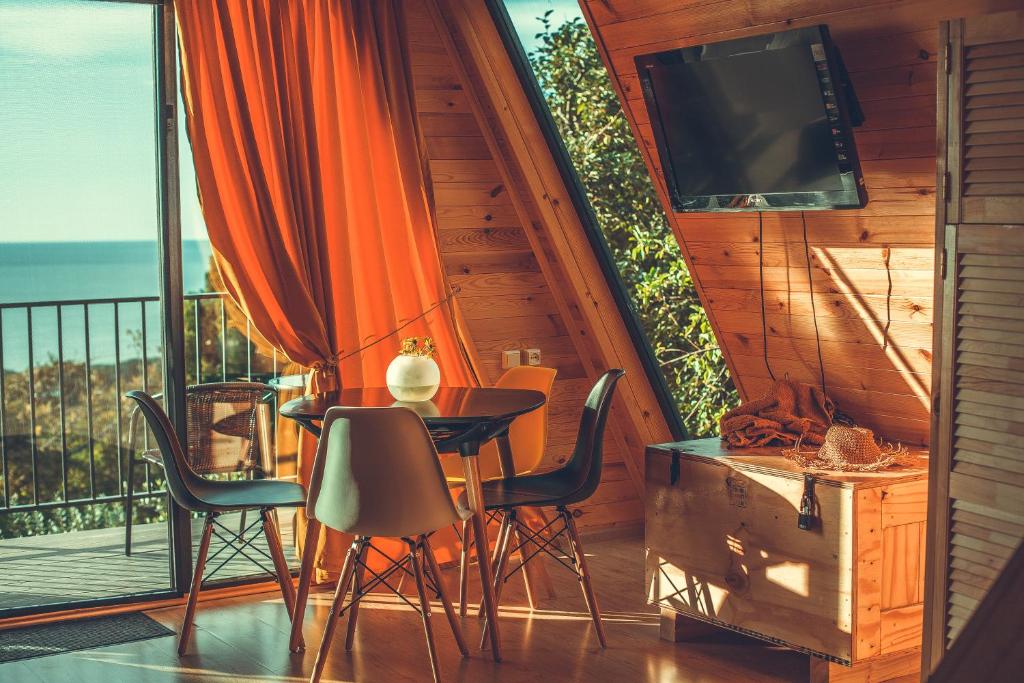 a balcony with a table and chairs and a television at Mandar Inn in Tsikhisdziri