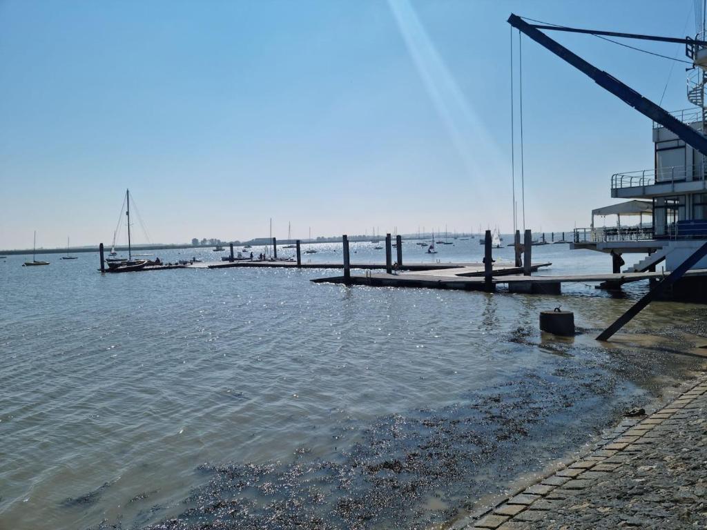 a dock in the water with boats in the water at Waterfront Retreat - Modern Apartment in Burnham-on-Crouch