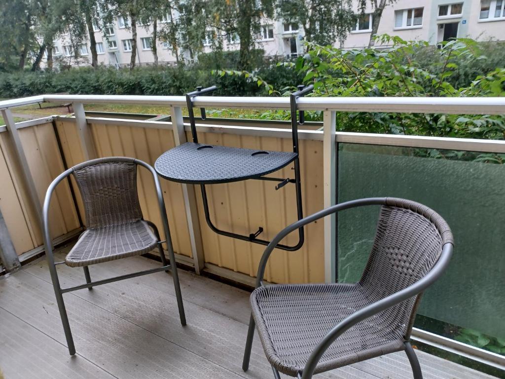 two chairs and a table on a balcony at FeWo s Runde Wiese LL in Greifswald