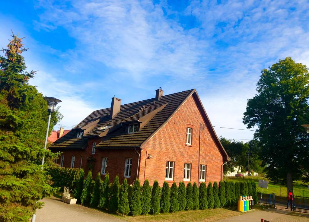 a large red brick house with a black roof at Baltic Home in Mielno