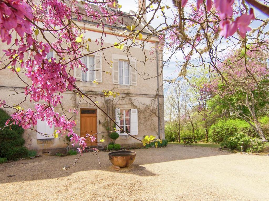 ein Haus mit rosa Blumen davor in der Unterkunft Manoir La Peyrade in Brouchaud