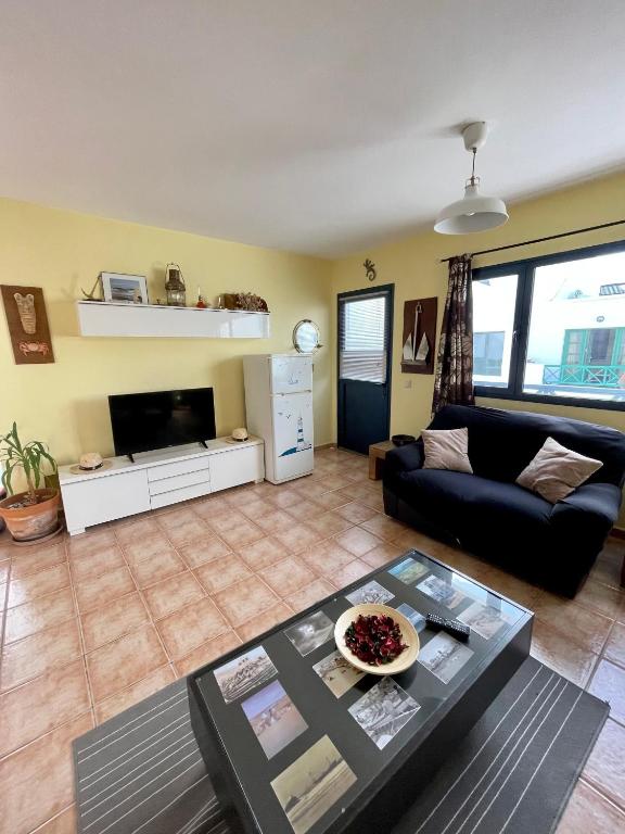 salon z kanapą i stołem w obiekcie apartamento anzuelo w mieście Famara