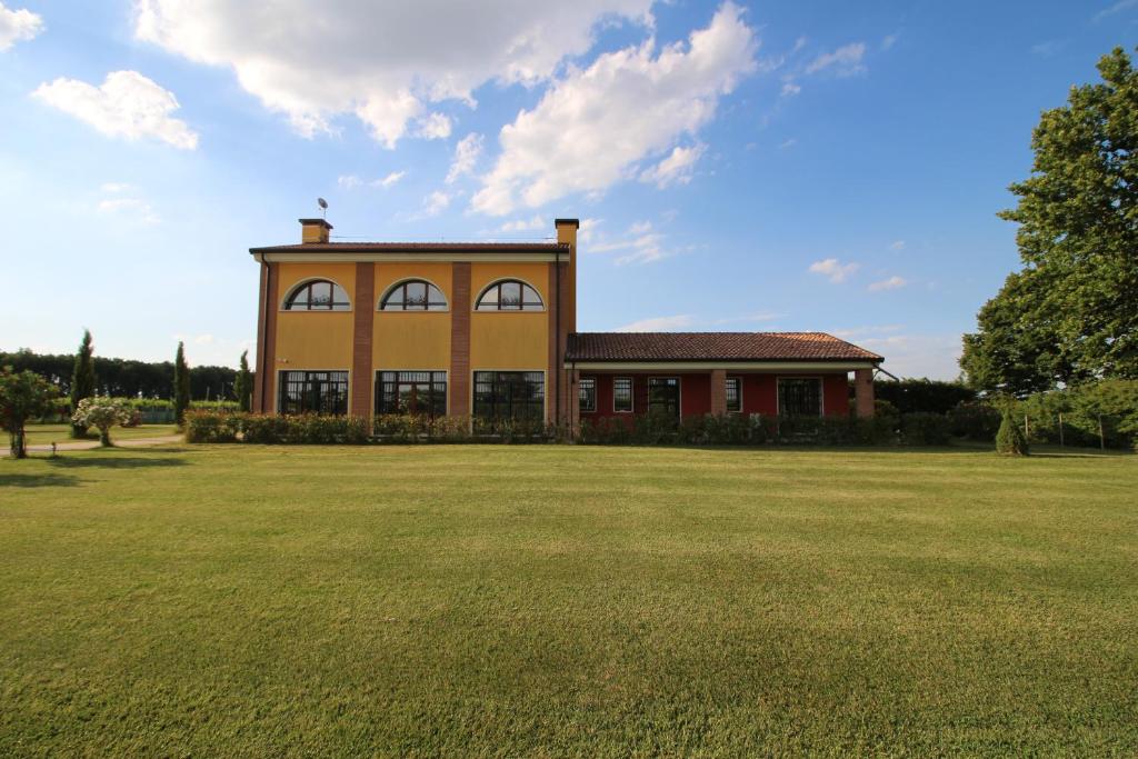 una casa grande con un gran campo de césped en B&B Ca' Bianca, en Adria