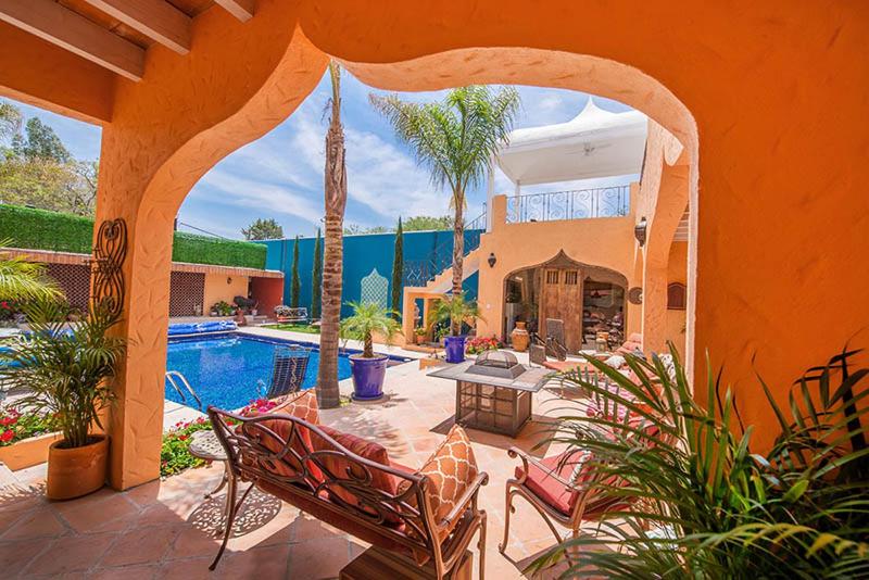 a home with a swimming pool and a patio with chairs at Oasis in San Miguel in San Miguel de Allende