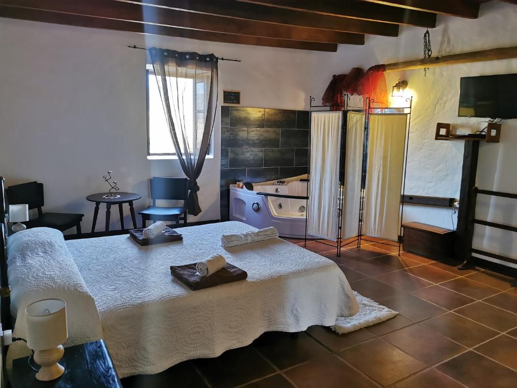 a bedroom with a bed and a bathroom with a tub at Villa Cecilio in Tefía