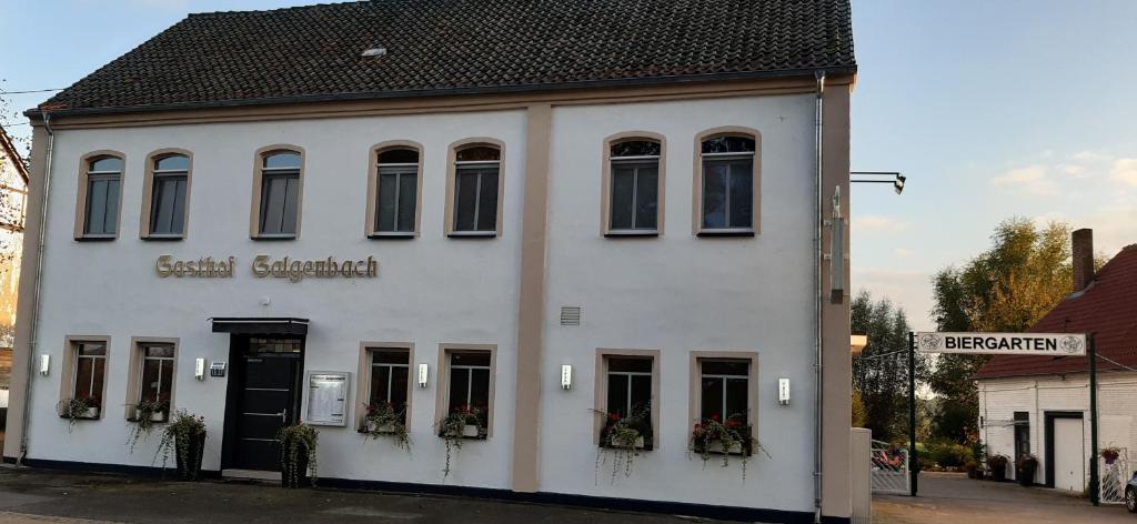 a white building with a sign on the side of it at Steakhaus Galgenbach in Werne an der Lippe