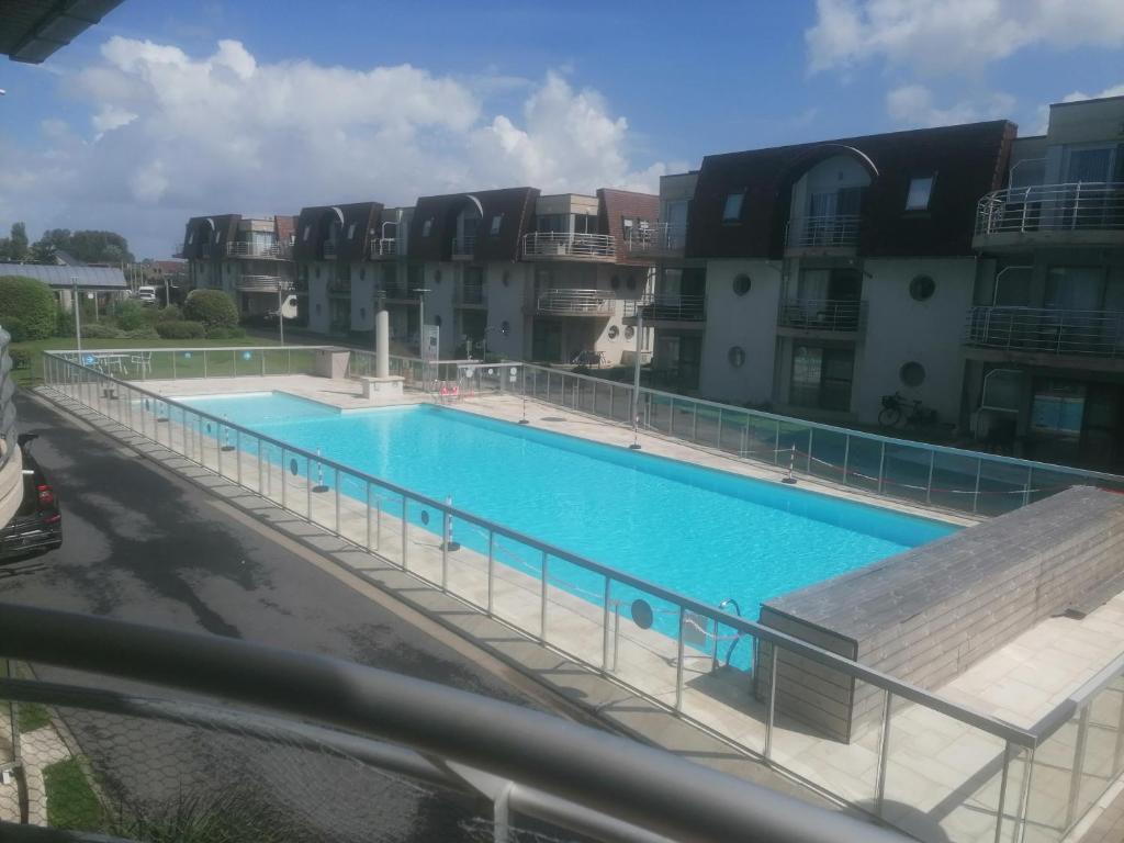 una grande piscina di fronte ad alcuni edifici di appartement zee zon en zwem a Bredene