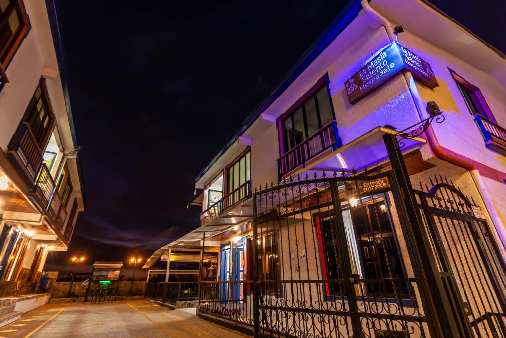 a building with colorful lights on it at night at Hospedaje La Masia Salento in Salento