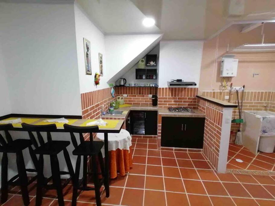 una cocina con mesa y algunas sillas. en Apartahotel El Mirador, en Zapatoca