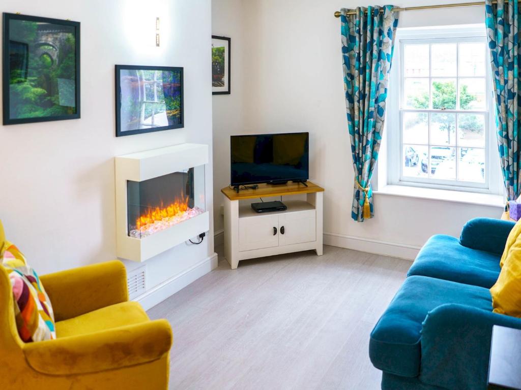 a living room with a fireplace and a tv at Pass The Keys Modern 2 bed flat overlooking Aberaeron Harbour in Aberaeron