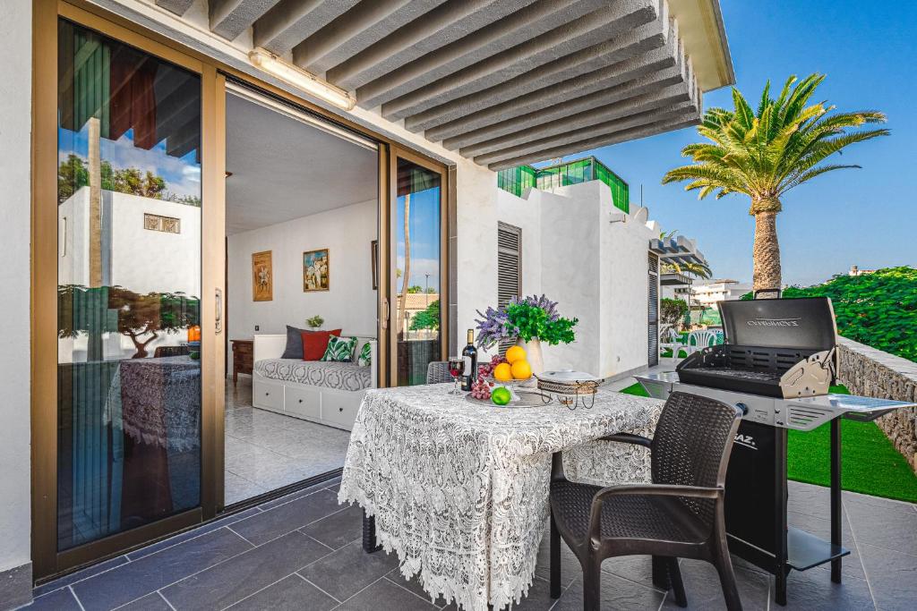 a patio with a table with a laptop on it at BUNGALOW -2 minute from the beach. in Playa de las Americas