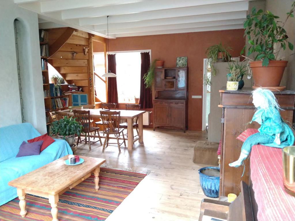 ein Wohnzimmer mit einem blauen Sofa und einem Tisch in der Unterkunft Logies de Zeeuwse Klei, een gezellig jaren 30 huis in Middelburg