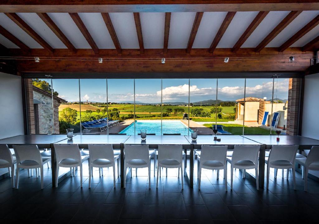 a dining room with a table and chairs and a large window at Borgo Solario in Castiglione del Lago