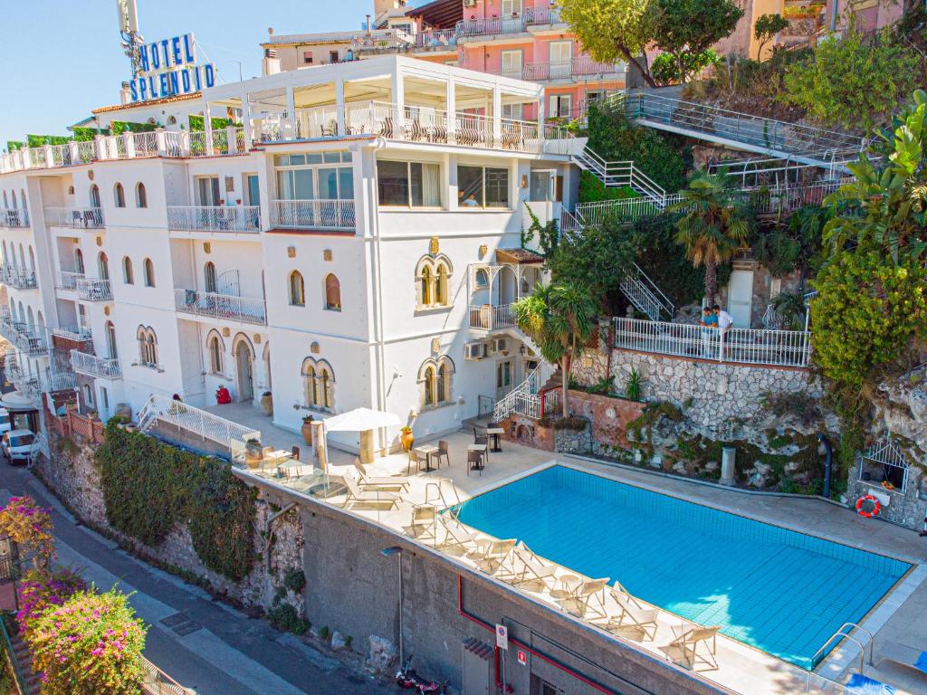 a hotel room with a pool and a balcony at Splendid Hotel Taormina in Taormina