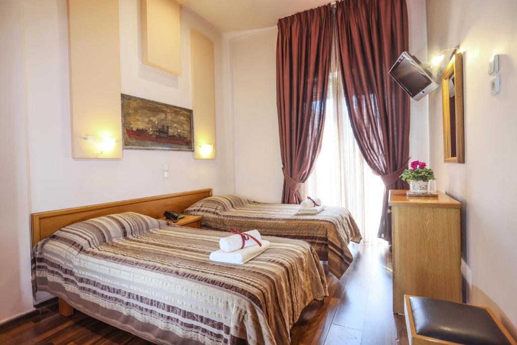 a hotel room with two beds and a window at Aegeon Hotel in Thessaloniki