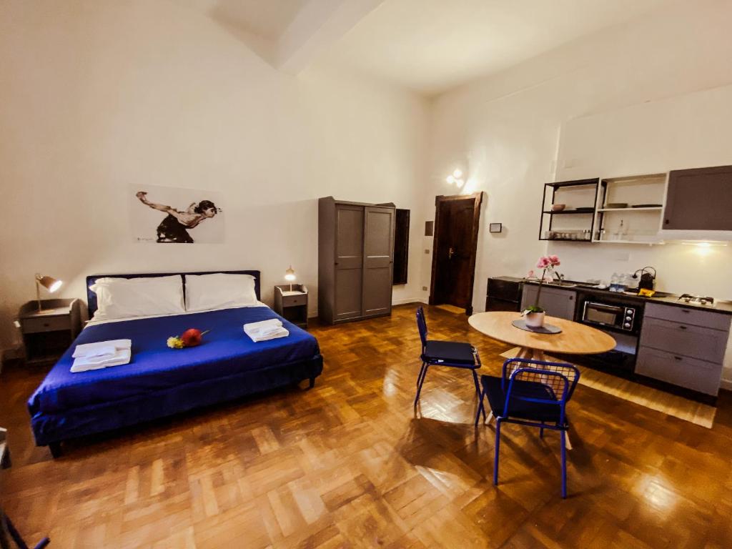 a bedroom with a bed and a table and a kitchen at Residenza Studio delle Arti in Bologna